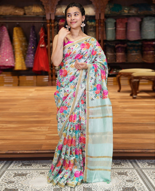 Sky Blue Banana Pith Saree Prettified with Multi-Color Rose Floral Motifs Print, Subtle Small Bavanji Border, Pallu Steeped with Zari Stripes, and Complemented with a Contrast Floral-Printed Blouse