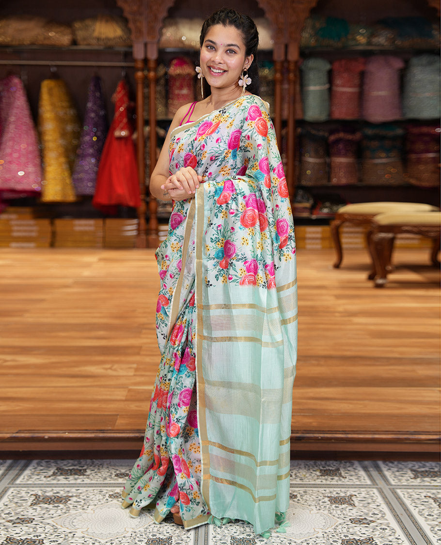 Sky Blue Banana Pith Saree Prettified with Multi-Color Rose Floral Motifs Print, Subtle Small Bavanji Border, Pallu Steeped with Zari Stripes, and Complemented with a Contrast Floral-Printed Blouse