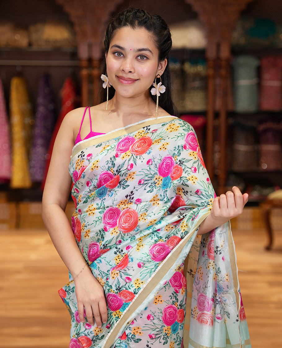 Sky Blue Banana Pith Saree Prettified with Multi-Color Rose Floral Motifs Print, Subtle Small Bavanji Border, Pallu Steeped with Zari Stripes, and Complemented with a Contrast Floral-Printed Blouse
