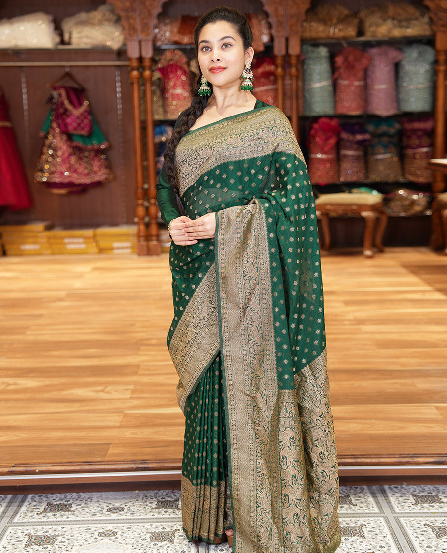 Green Semi-Banaras Khaddi Georgette, Finely Detailed with Zari Buttas All Over Its Body,  Subtly Sparkled Traditional Border of Rudraksham, Elephant, and Floral Vine Designs, Pallu of a Herd of Elephants, and Paired with a Matching Blouse