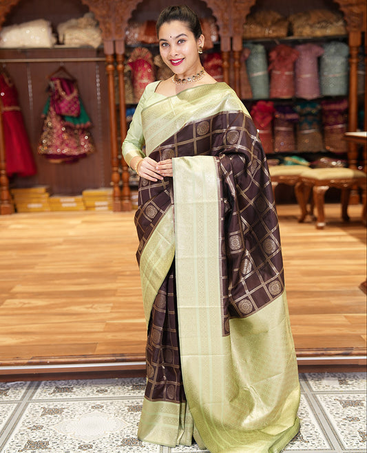 Coffee Brown and Elaichi Green Litchi Saree Elegantly Decked up with Chakra Butta Enclosed Zari Checks, Complemented by a Contrast Border Steeped with Chakram Motifs, Pallu Featuring Intricate Designs, and Comes with a Contrast Blouse