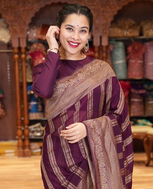 Wine Fancy Khaddi Georgette Adorned with Geometric Patterns in Zari, Subtly Woven Border Steeped with Traditional Designs, Richly Woven Pallu of Jaal Designs, and Paired with a Matching Blouse