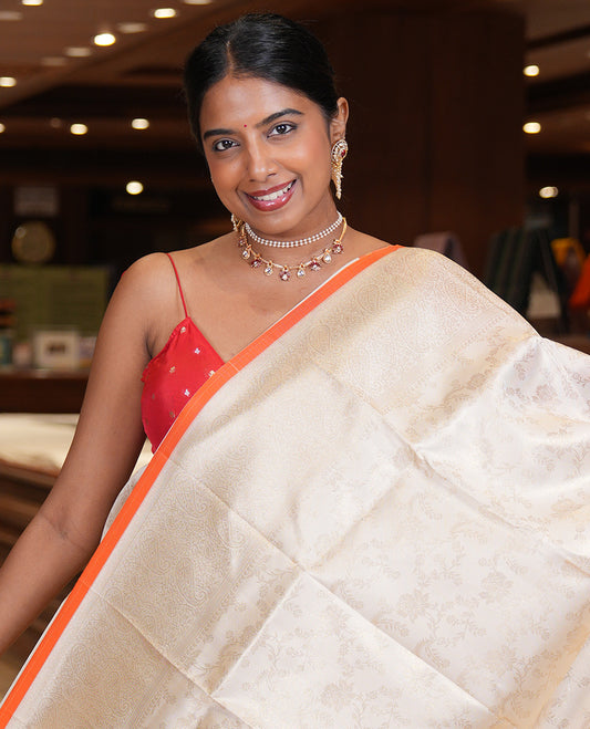 Off-White-Orange Semi-Silk Saree, Adorned with Floral Jacquard Design, a Zari Paisley Border, and a Contrast Blouse