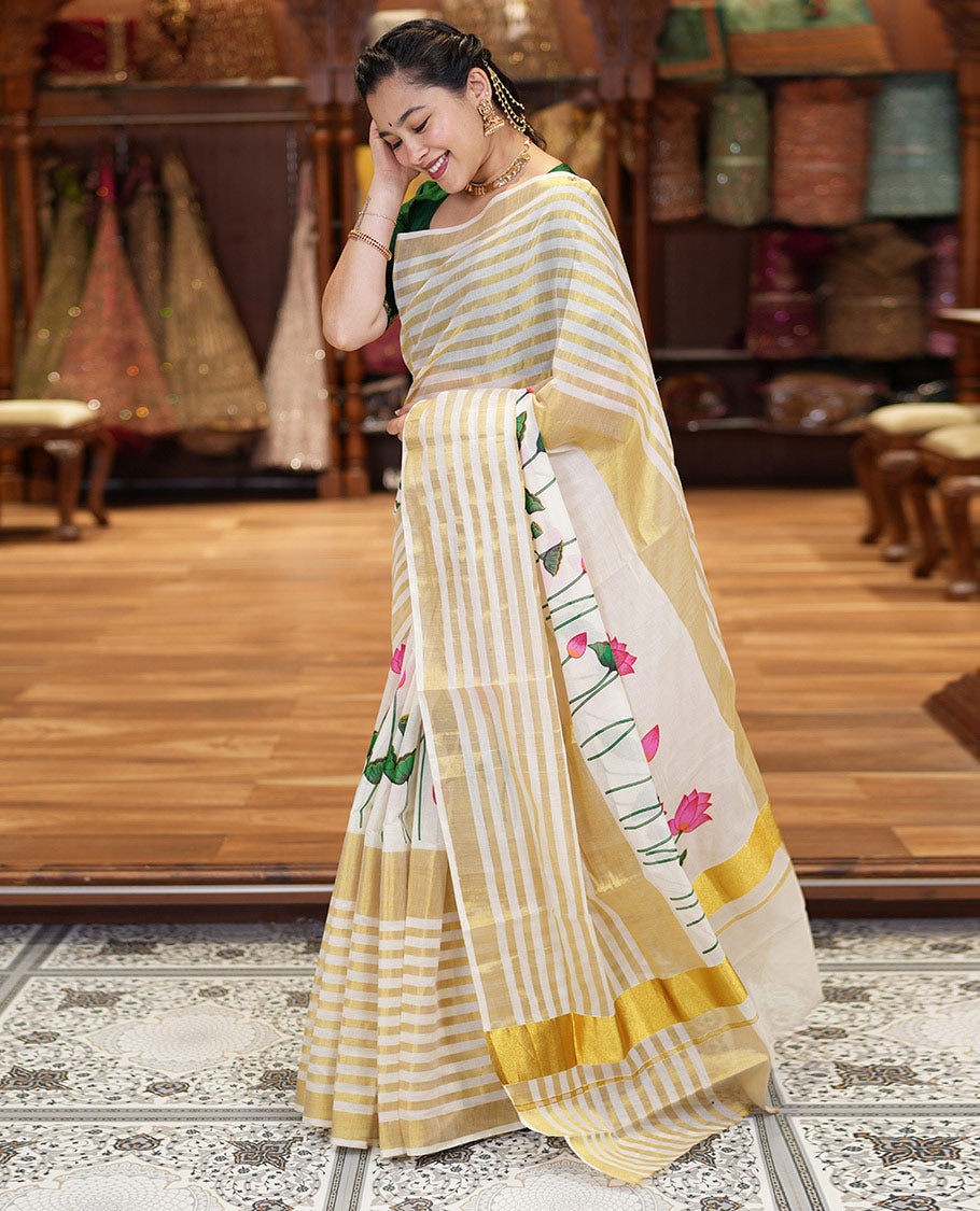 Cream Kerala Cotton Saree, Gleamed Up with Horizontal Zari Stripes and Pichwai Lotus Print All Over Its Body, Subtle Zari Border, Pallu Mirrors Pichwai Lotus Print, and Paired with a Matching Blouse