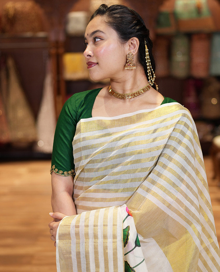 Cream Kerala Cotton Saree, Gleamed Up with Horizontal Zari Stripes and Pichwai Lotus Print All Over Its Body, Subtle Zari Border, Pallu Mirrors Pichwai Lotus Print, and Paired with a Matching Blouse