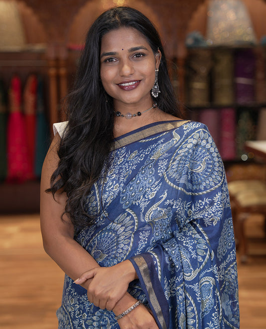 Indigo Blue Muslin Cotton Saree, Beautified with Round Peacock Motifs and Floral Print on Its Body, a Subtle Zari Border, Striped Pallu, and Matching Blouse