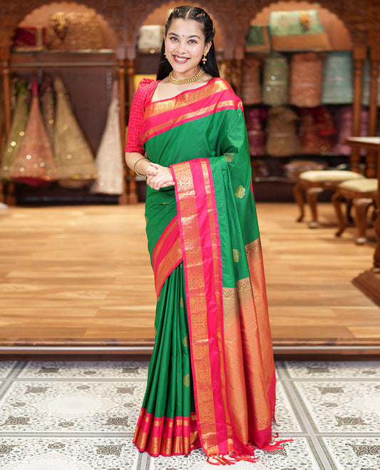 Green Kanchipuram Budget Silk Saree, Detailed with Zari Buttas All Over Its Body, Complemented by a Contrast Traditional Zari Rettai Pettu Border of Chakram Designs, Gracefully Embellished Pallu, and Paired with a Contrast Blouse