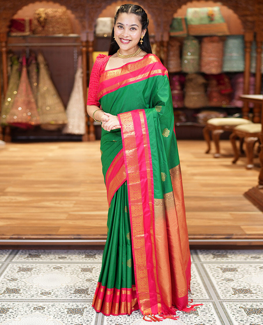 Green Kanchipuram Budget Silk Saree, Detailed with Zari Buttas All Over Its Body, Complemented by a Contrast Traditional Zari Rettai Pettu Border of Chakram Designs, Gracefully Embellished Pallu, and Paired with a Contrast Blouse