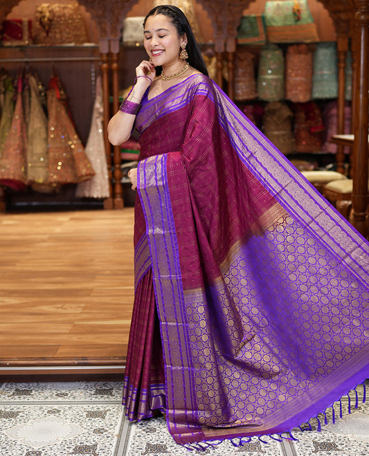 Maroon Kanchipuram Budget Silk Saree, Ornamented with Plus-Sized Butta Enclosed Checks All Over Its Body, Complemented by a Contrast Traditional Zari Border of Round Peacock Designs, Pallu Steeped with Circle Motifs, and Paired with a Contrast Blouse