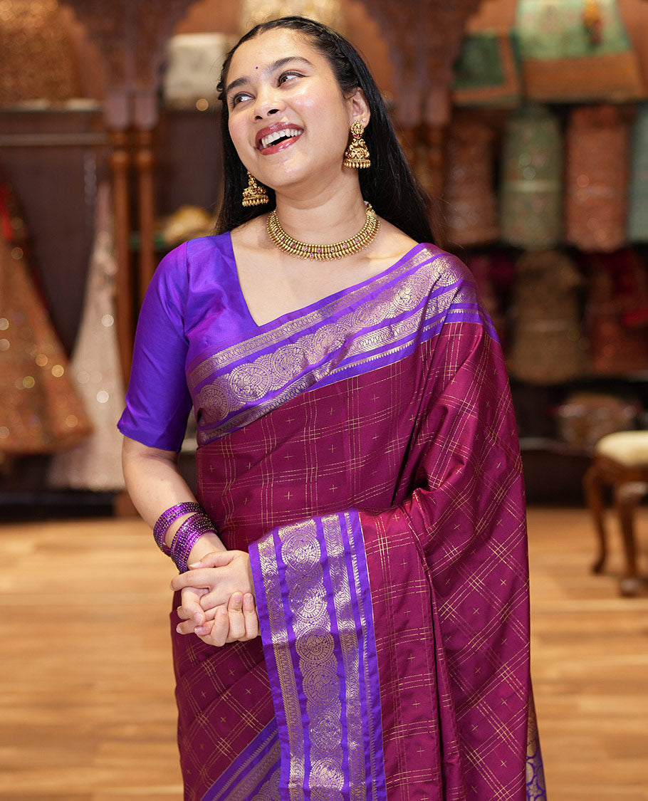 Maroon Kanchipuram Budget Silk Saree, Ornamented with Plus-Sized Butta Enclosed Checks All Over Its Body, Complemented by a Contrast Traditional Zari Border of Round Peacock Designs, Pallu Steeped with Circle Motifs, and Paired with a Contrast Blouse