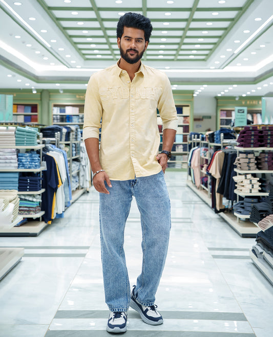 Cream Cotton Blended Casual Shirt, Bedecked with Acid-Washed and Typography Patch Embroidery on the Chest, Featuring a Spread Collar, Full Sleeves, Slim Fit, and Regular Length