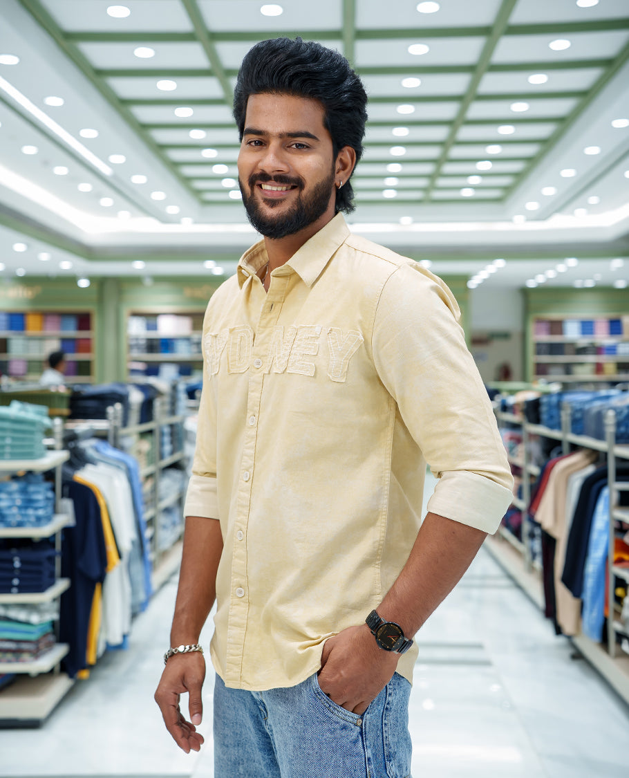 Cream Cotton Blended Casual Shirt, Bedecked with Acid-Washed and Typography Patch Embroidery on the Chest, Featuring a Spread Collar, Full Sleeves, Slim Fit, and Regular Length