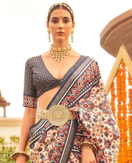 Multi-color intricate patola printed designer saree, contrast blue ikkat border, and floral design pallu