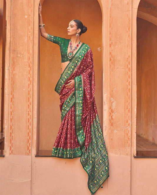 Maroon Ikat Patola Designer Saree, Ornamented with Floral Ikat Buttas, Complemented by a Contrast Ikat Border, Intricate Pallu, and a Contrast Blouse