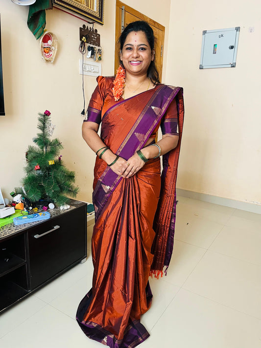 Rust orange buttas woven saree with contrast traditional temple border, and zari striped pallu