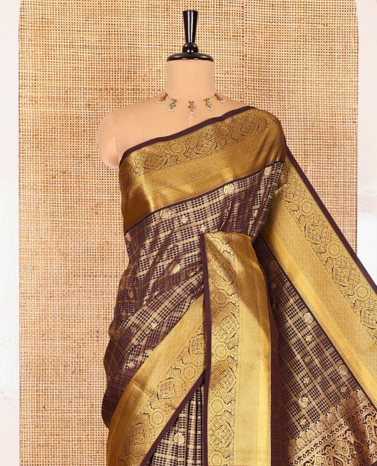 Brown Kanchipuram budget silk saree enriched with zari butta enclosed checks all over its body, complemented by zari traditional design border, Mughal-style intricate pallu, and paired with a Matching blouse