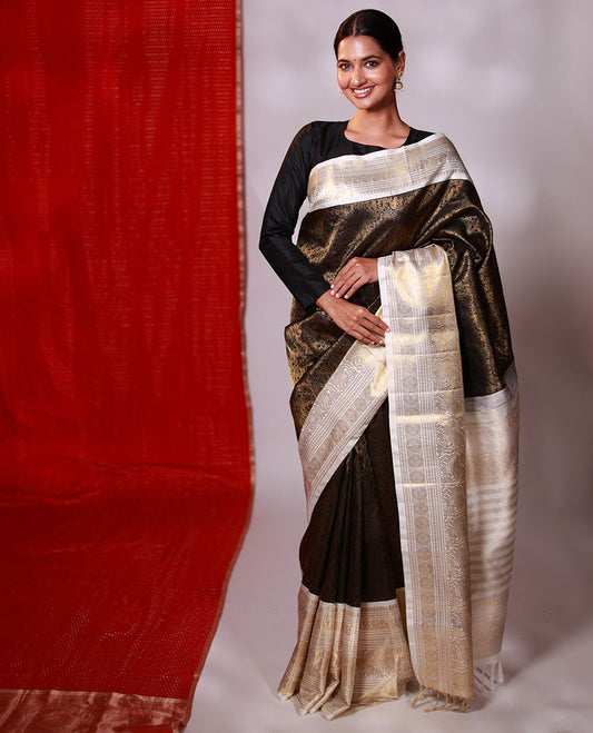 Black jacquard Kanchipuram silk saree, contrast korvai border of manga mokku, neli, banaras, mayil, kuthirai, poun, and poo chakram designs, and zari-rich pallu