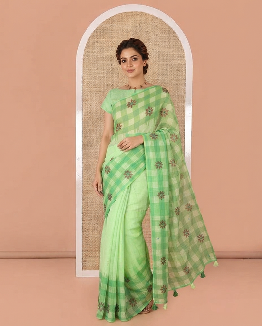 Green Linen Cotton Saree, Gleamed up with Mirror Work On Its Body, Complemented by Contrast Temple Checked Border of Floral Print and Mirror Work, Pallu Mirrors the Same Design and Paired with a Contrast Blouse