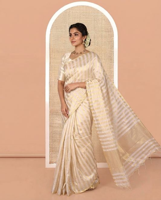 Borderless Off-white Tissue Saree, Entralled with Thick Vertical Golden Zari Stripes All Over Its Body, Highlighted by Gleaming Zari Striped Pallu, and Paired with a Matching Blouse