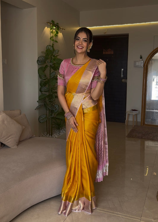 Mustard Yellow-Beach Pink Vasundhara Silk Saree, Richly Detailed with Zari Buttas, Complemented by Contrast Border of Kamalam, Muthu, Cross Kamalam, Rudraksham, and Thilakam Design, Pallu Steeped with Thilakam Designs, and Paired with a Contrast Blouse