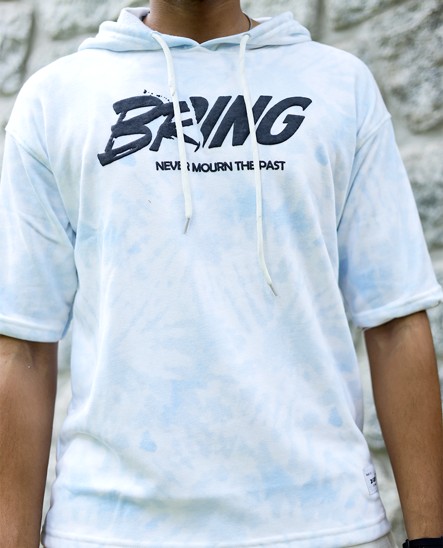 Light Blue Cotton-Blended Oversized Hooded T-Shirt Features Abstract Dyed Typography Print, Half-Sleeves, and Regular Length