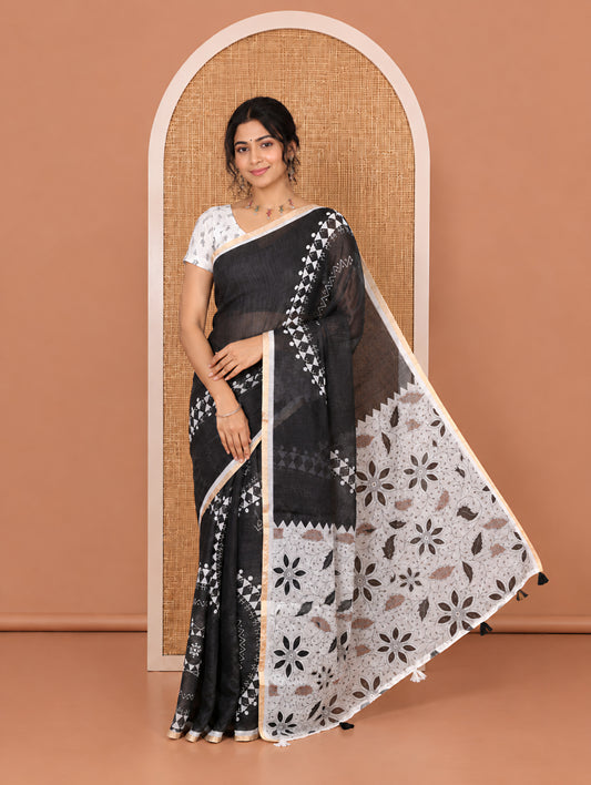 Black Orange Linen Cotton Saree Features Warli Print, a Contrast Piping Border, a Floral-Printed Pallu, and a Contrast Blouse