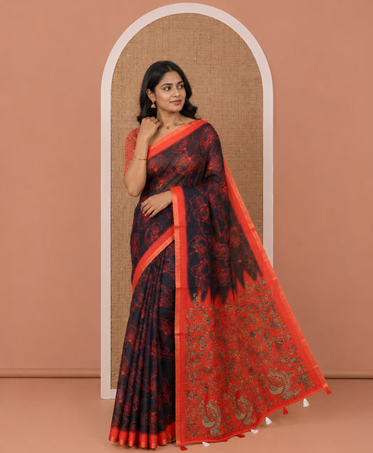 Black floral printed linen cotton saree, contrast piping border, kalamkari floral and peacock printed pallu, and a contrast floral vine printed blouse