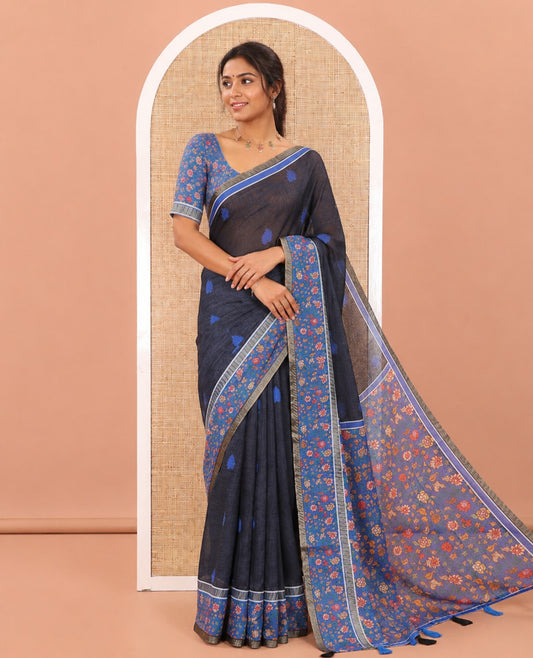 Black Linen Saree Adorned with Leaf Motifs All Over Its Body, Complemented by a Contrast Floral Vine Printed Border, Pallu Mirrors the Floral Vine Print, and Paired with a  Contrast Floral Printed Blouse