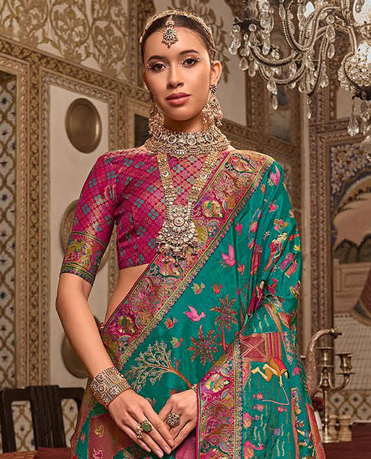 Green Designer Saree, Enthralled with Village-Theme Designs All Over Its Body, Complemented by a Contrast Colorful Meenakari Mughal-Style Border, Artfully Detailed Pallu, and Paired with a Contrast Blouse