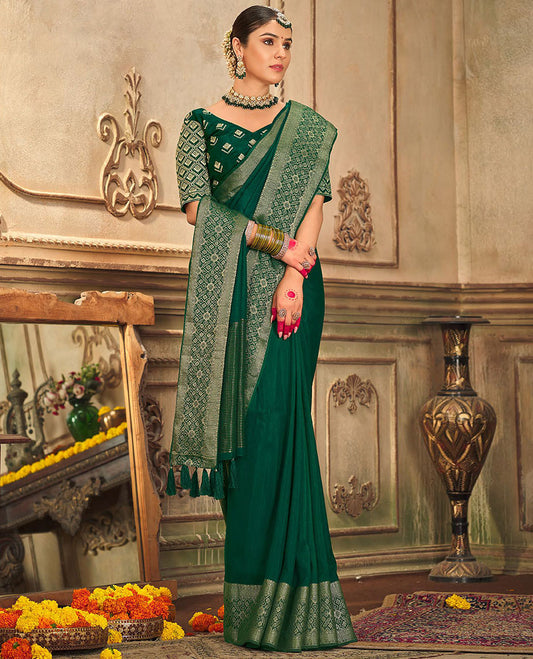 Dark green plain designer saree, patola-style motifs woven border, and zari striped pallu