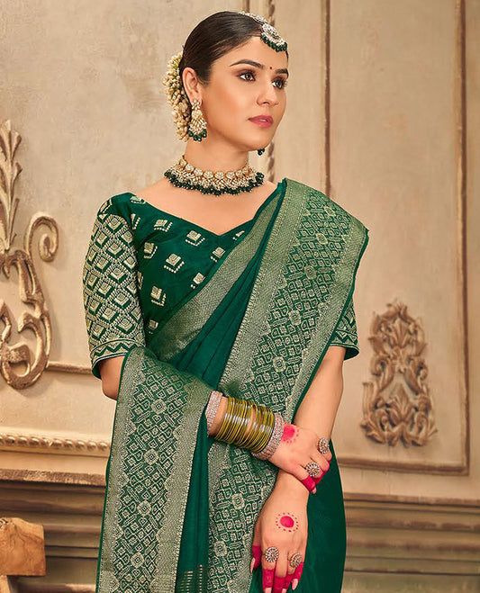 Dark green plain designer saree, patola-style motifs woven border, and zari striped pallu