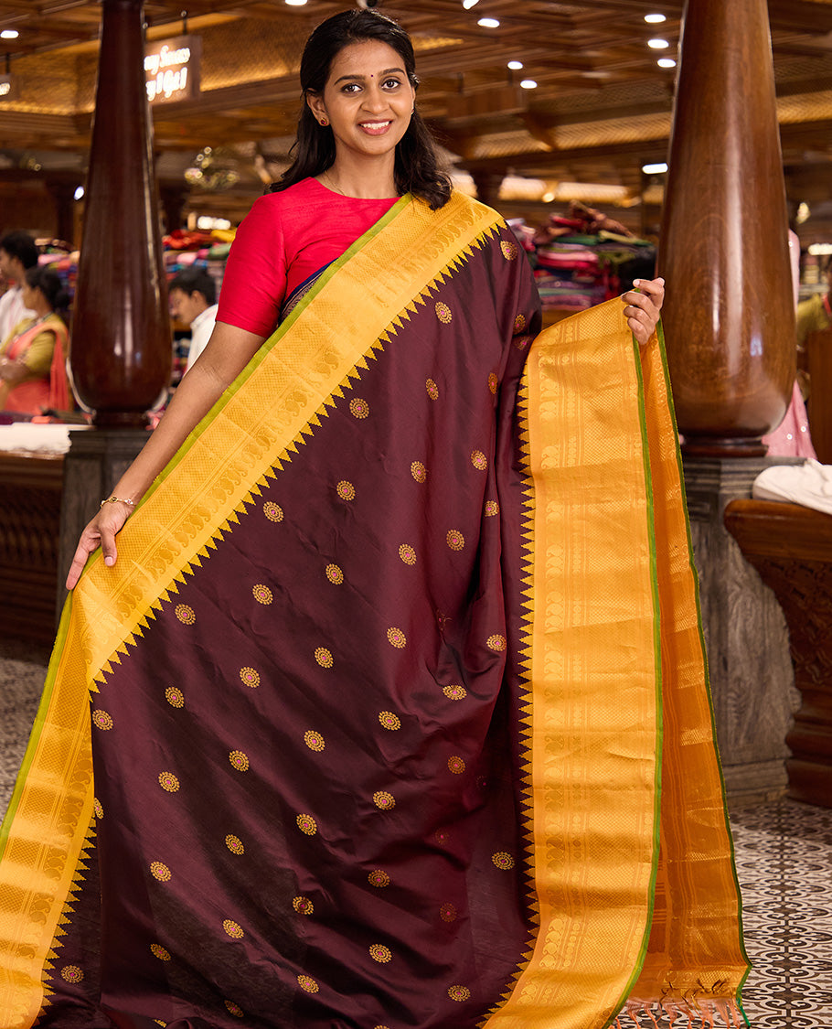 Maroon meena chakram buttas gadwal silk saree, contrast thazampoo rekku border of manga mokku, kathir, laddu kamalam, and mayil kann designs