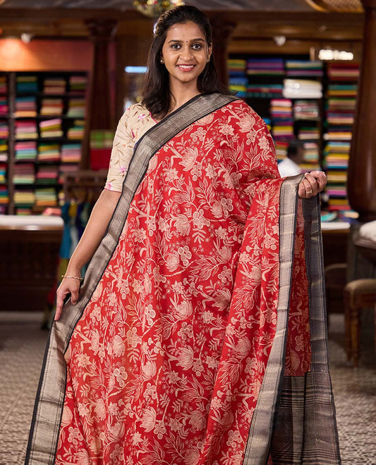 Red floral printed muga silk saree, contrast zari traditional temple border, and gleaming zari striped pallu
