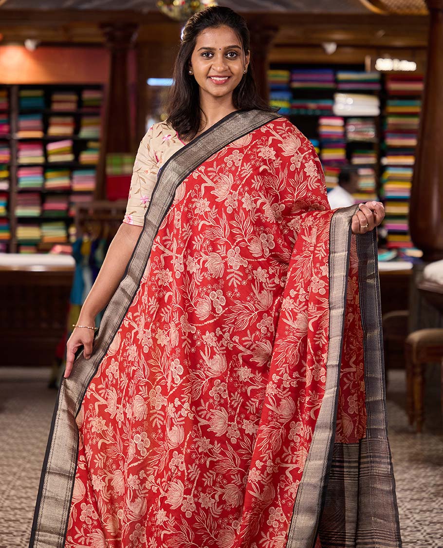 Red floral printed muga silk saree, contrast zari traditional temple border, and gleaming zari striped pallu