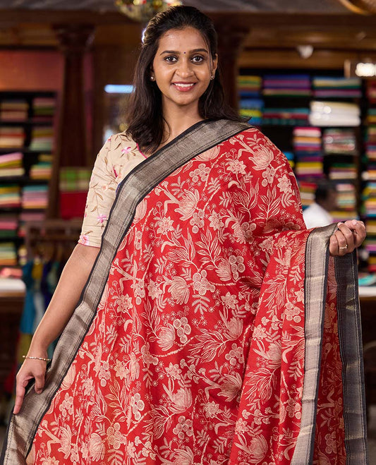 Red floral printed muga silk saree, contrast zari traditional temple border, and gleaming zari striped pallu