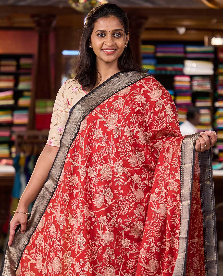 Red floral printed muga silk saree, contrast zari traditional temple border, and gleaming zari striped pallu