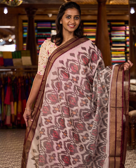 Pastel pink Pochampally Ikkat-style ogee patterned silk cotton saree, contrast zari border, and ikkat design pallu