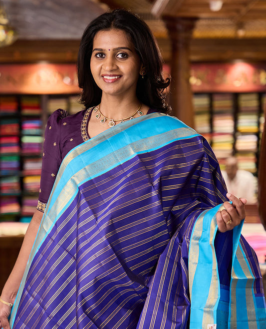 Blue zari striped Kanchipuram silksaree, contrast rettai pettu border of traditional zari designs, and zari-rich jaal pallu