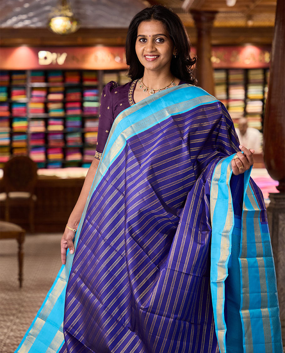 Blue zari striped Kanchipuram silksaree, contrast rettai pettu border of traditional zari designs, and zari-rich jaal pallu