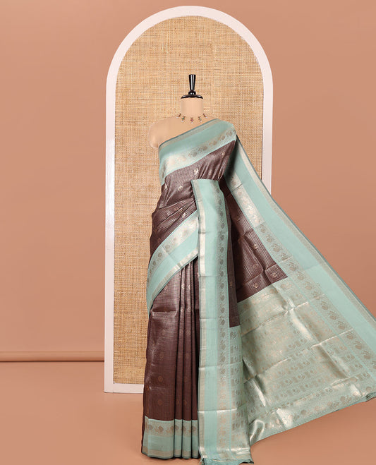 Coffee Brown Litchi Saree Decorated with Peacock Chakram Butta Enclosed Zari Checks, Complemented by a Contrast Rettai Pettu Border of Peacock Designs, Intricately Woven Pallu Steeped with Peacock Designs, and Paired with a Contrast Blouse