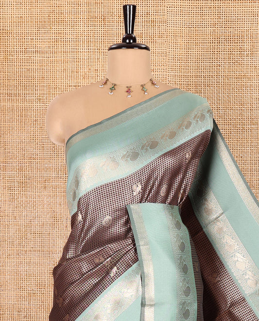 Coffee Brown Litchi Saree Decorated with Peacock Chakram Butta Enclosed Zari Checks, Complemented by a Contrast Rettai Pettu Border of Peacock Designs, Intricately Woven Pallu Steeped with Peacock Designs, and Paired with a Contrast Blouse