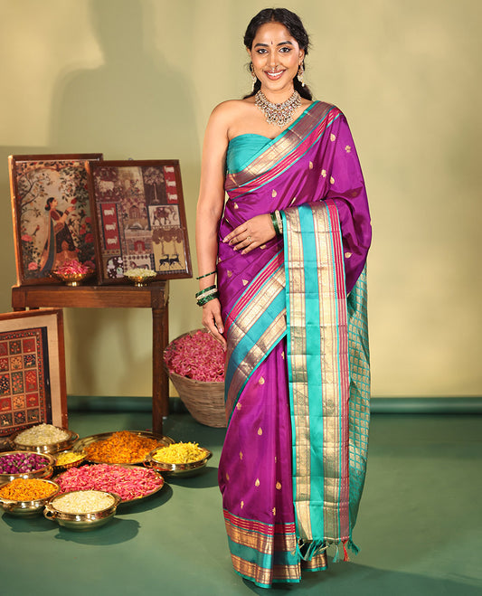 Purple Vasundhara Silk Saree, Beautifully Bedecked with Kamalam Buttas on Its Body, Complemented by a Captivating Contrast Border of Muthu, Chakram, and Mayil Kann Designs, Grand Jaal Pallu, and Paired with a Contrast Blouse