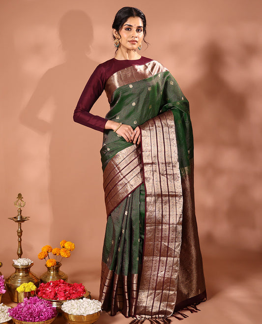 Emerald green striped and annam chakram buttas silk saree, contrast varisai pettu border of rekku, mayil and yaanai designs, and zari rich intricate pallu
