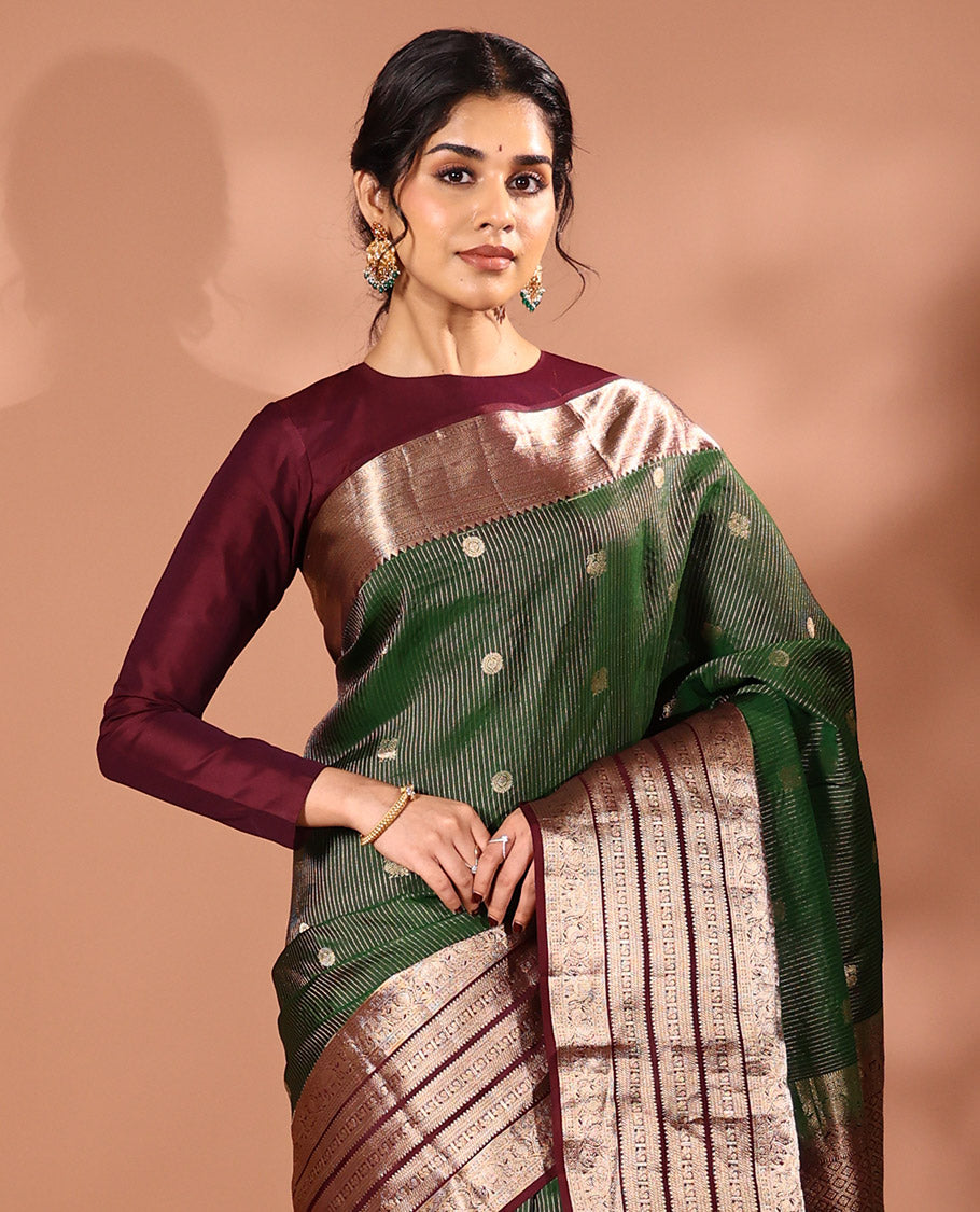 Emerald green striped and annam chakram buttas silk saree, contrast varisai pettu border of rekku, mayil and yaanai designs, and zari rich intricate pallu