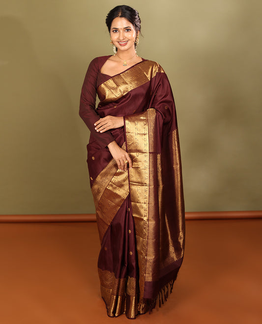 Brown Kanchipuram Silk Saree, Adorned with Zari Buttas, a Zari Border of Iruthalai Pakshi, Thilakam, Kathir, Mayil, Yaanai, and Mayil Kann Designs, Jaal Pallu, and a Matching Blouse