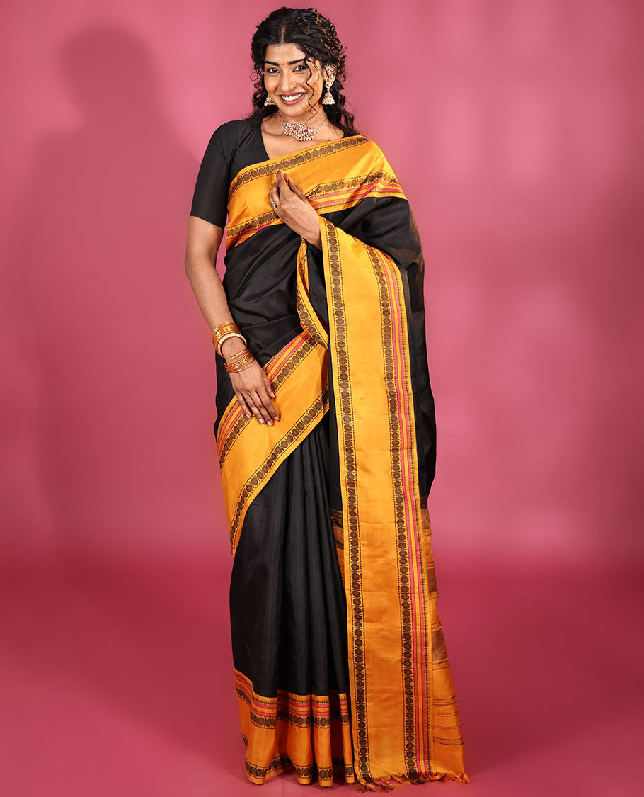 Black Plain Kanchipuram Silk Saree, Complemented by Captivating Contrast Rettai Pettu Border of Rekku, Muthu, and Rudraksham Designs, a Subtle Pallu of Thread Weave, and Paired with a Contrast Blouse