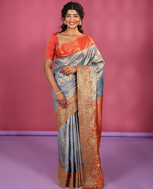Blue Vastrakala Silk Saree, Adorned with Floral Jacquard and Stone Work, Complemented by Contrast Traditional Zari and Cut Embroidered Scallop Border, Gleaming Grand Zari-Stone Work Pallu, and Paired with Contrast Heavy Stone Embroidered Blouse