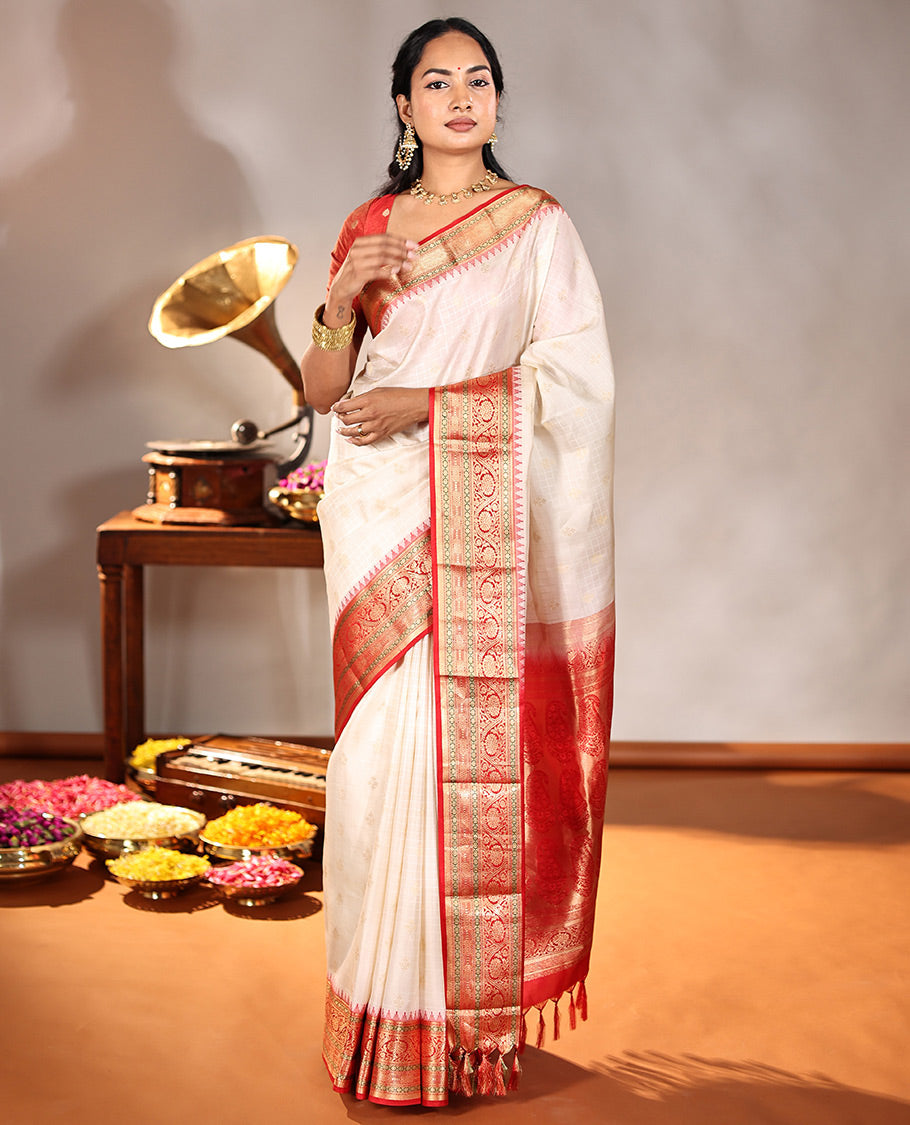 Cream Vasundhara Silk Saree, Subtly Sparkled with Buttas And Checks On Its Body, Complemented by Captivating Contrast Border of Thazampoo Rekku, Muthu, Banaras, and Kodi Visiry Designs, Pallu Steeped with Manga Designs, And Paired with a Contrast Blouse