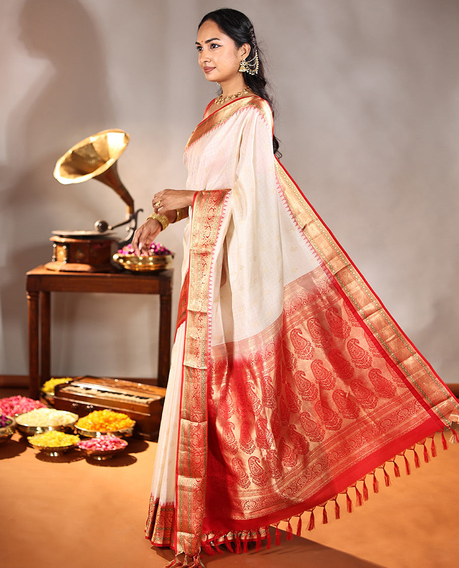 Cream Vasundhara Silk Saree, Subtly Sparkled with Buttas And Checks On Its Body, Complemented by Captivating Contrast Border of Thazampoo Rekku, Muthu, Banaras, and Kodi Visiry Designs, Pallu Steeped with Manga Designs, And Paired with a Contrast Blouse