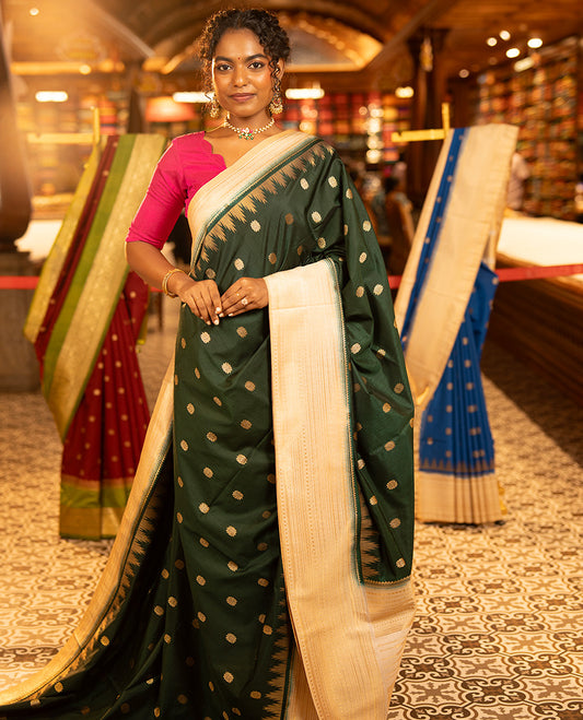 Bottle Green Dupion Silk Saree, Elevated with Zari Buttas All Over Its Body, Complemented by a Contrast Temple Traditional Zari Design Woven Border, Traditional Pallu of Temple Designs, and Paired with a Contrast Blouse